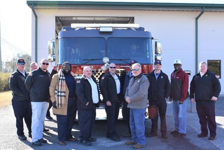 Photo of dignitaries and firefighters in front of new fire truck